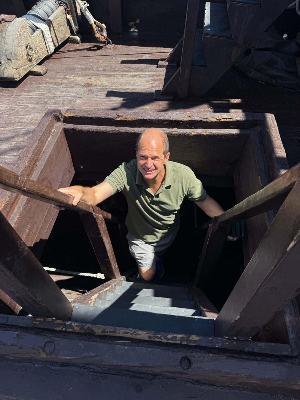 Graham Balch emerging from a hatch below deck on the Santa María replica