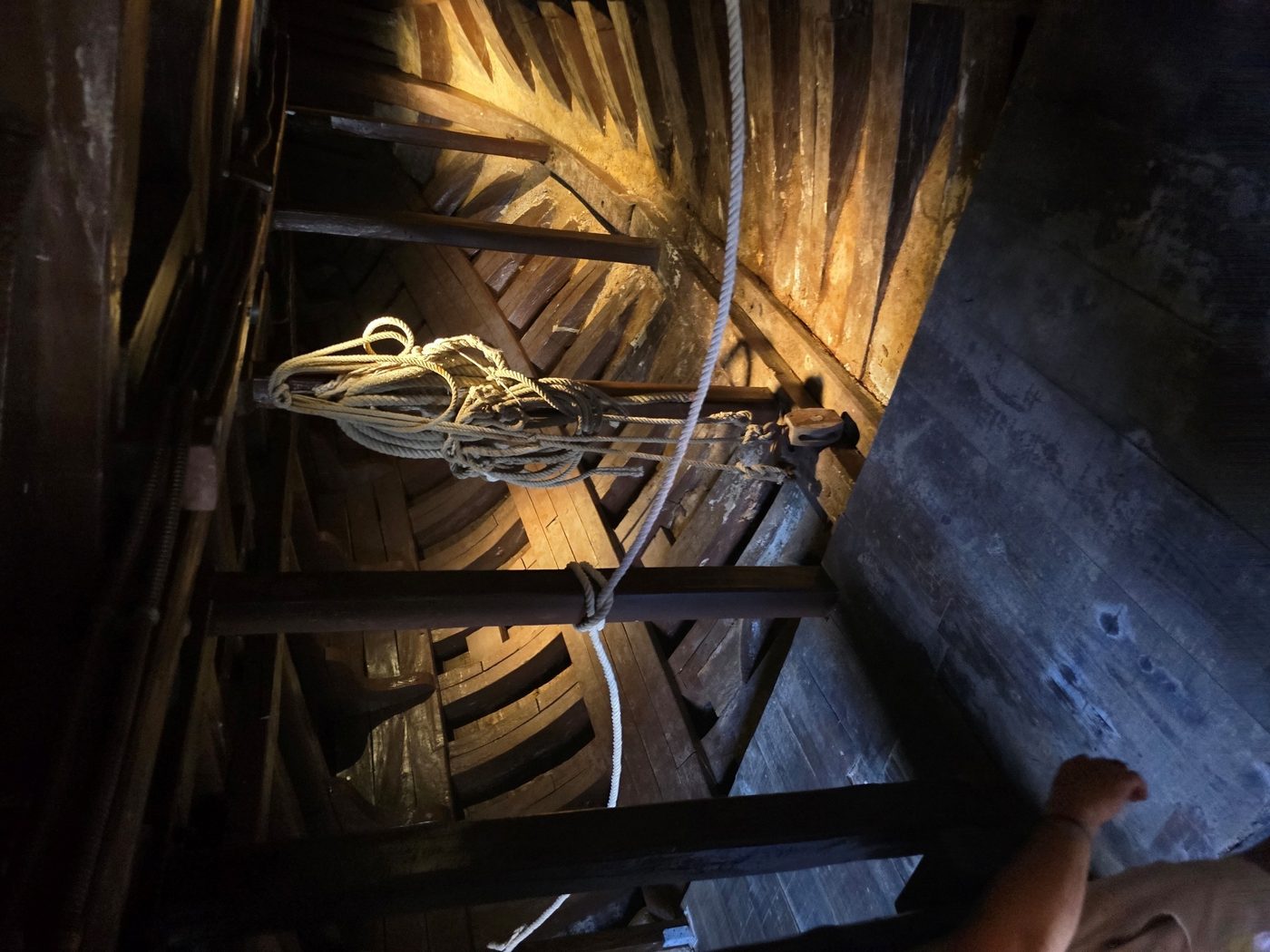 Looking up into the wooden rigging and hull structure from inside the ship